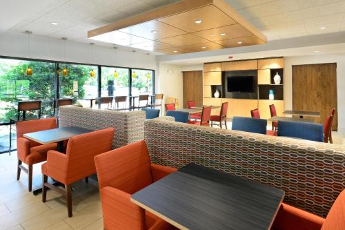 a restaurant with tables and chairs and a counter at Holiday Inn Express & Suites Raleigh Durham Airport at RTP by IHG in Durham