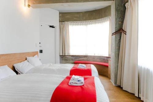 a hotel room with two beds with red blankets at Romance za Kado in Atami