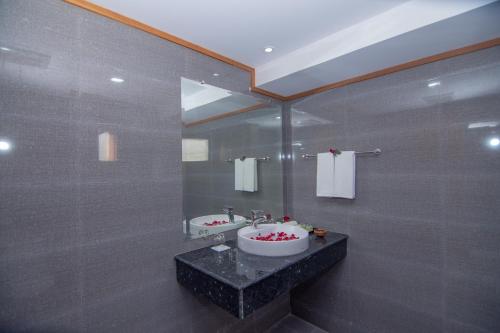 een badkamer met een wastafel en een spiegel bij Ngapali Win Hotel in Ngapali