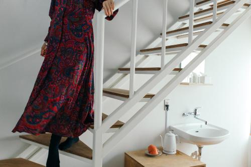 a woman in a dress is standing on a stairs at Romance za Kado in Atami