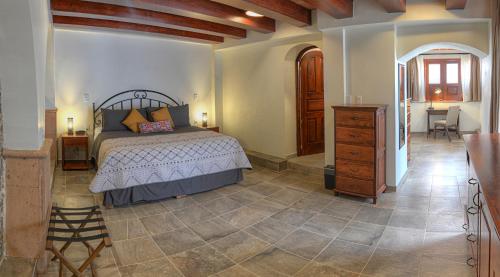 a bedroom with a bed and a dresser at Hotel Santa Paula in Taxco de Alarcón
