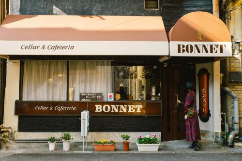 a woman standing in front of a store at Romance za Kado in Atami