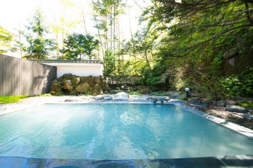 a swimming pool in a yard with trees at Bourou NOGUCHI Noboribetsu (Adult Only) in Noboribetsu