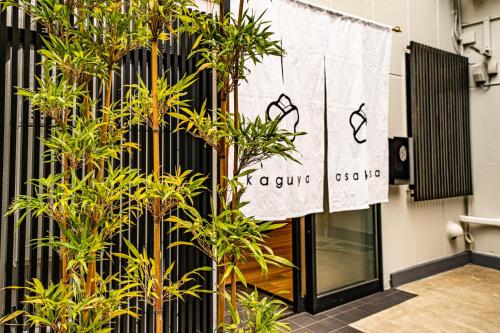 a sign on the side of a building with plants at kaguya asakusa Women only guest house in Tokyo