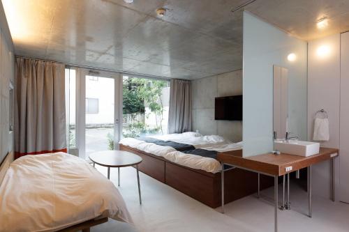 a bedroom with a bed and a desk and a sink at URBAN LODGE Komagome in Tokyo