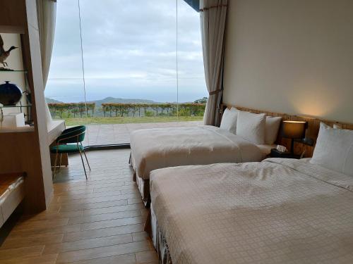 a hotel room with two beds and a large window at Fu Yuan Tan Villa in Fuyuan