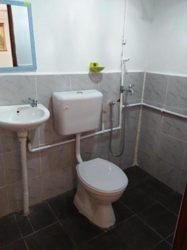 a bathroom with a toilet and a sink at CHALET WARISAN SINERGI in Lubuk Cina