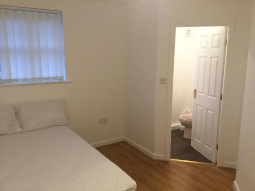 a small bedroom with a bed and a toilet at Quiet Residential Area Within Easy Reach Of Town in Manchester