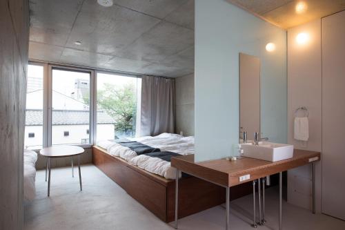 a bedroom with a bed and a sink and a mirror at URBAN LODGE Komagome in Tokyo