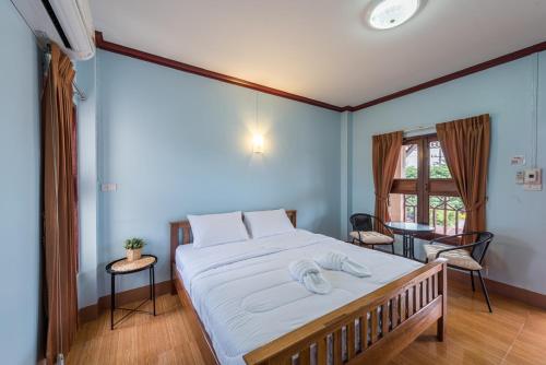 um quarto com uma cama grande e lençóis brancos em Primmalyn บ้านพริมมาลีณ em Chiang Khan