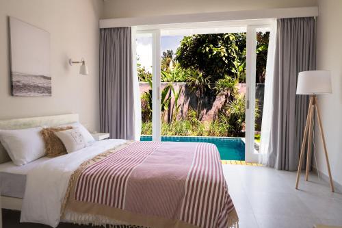 1 dormitorio con cama y ventana grande en GOOD STORY VILLAGE en Ahangama