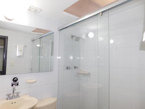 a bathroom with a shower and a toilet and a sink at Hotel Casa Navi in Bogotá