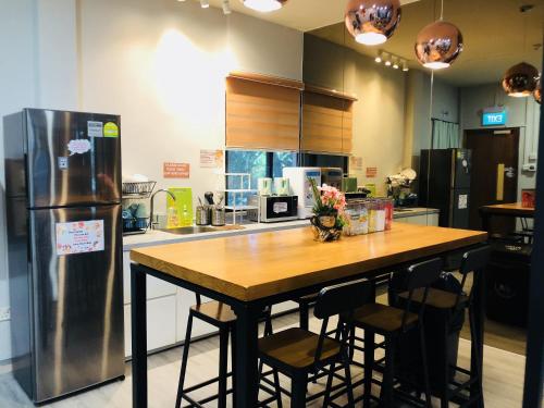 新加坡的住宿－CapsulePod@Aljunied，厨房配有木桌和冰箱。