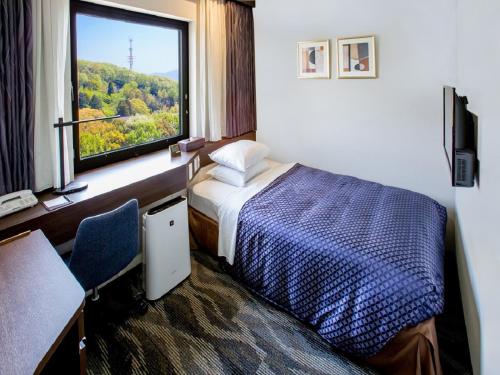 a hotel room with a bed and a window at Okayama International Hotel in Okayama