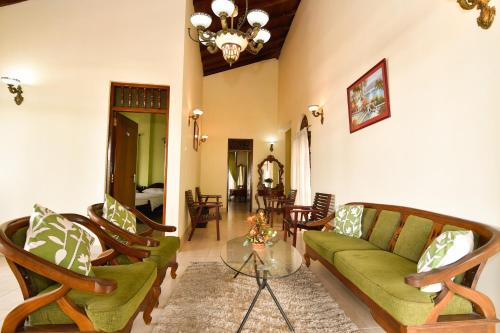 un salon avec un canapé et des chaises vertes dans l'établissement Expeditor Kandy, à Kandy