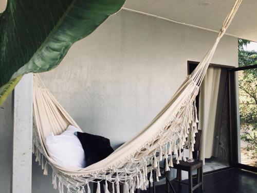 a hammock with a bed in a room at My home resort - ขนอม นครศรีธรรมราช in Khanom