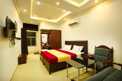 - une chambre avec un lit, un bureau et un canapé dans l'établissement karibu Residency, à Malappuram