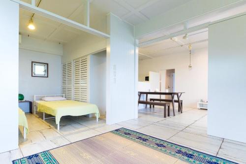 uma sala de estar com uma cama e uma mesa em amber moon em Ishigaki Island