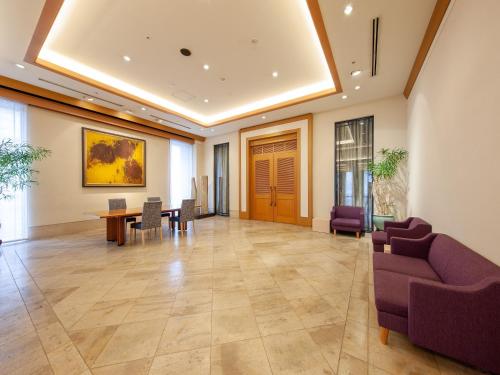 an office lobby with a couch and a table at President Hotel Mito in Mito