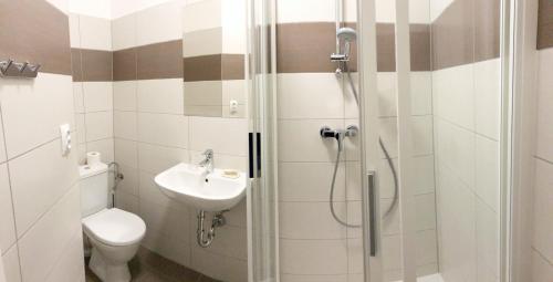 a bathroom with a shower and a toilet and a sink at Hotel U námořníka in Plzeň