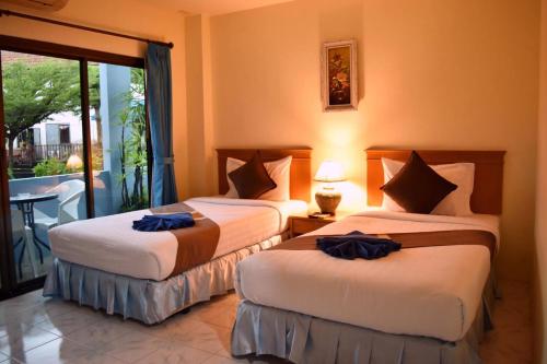 2 bedden in een kamer met een balkon bij Pailin Hotel in Klong Muang Beach