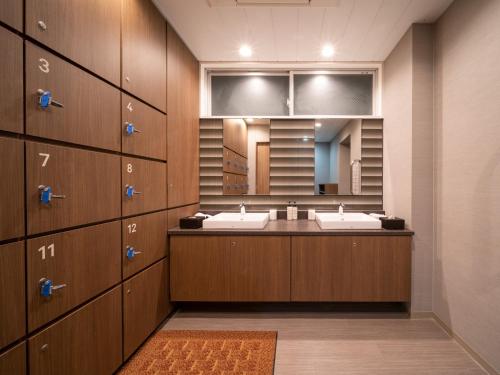 ein Badezimmer mit zwei Waschbecken und einem großen Spiegel in der Unterkunft Super Hotel Marugame Ekimae in Marugame