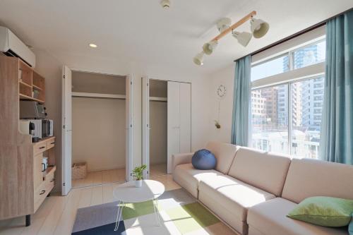 a living room with a couch and a large window at V.Close to Nishi-Shinjuku/FrWIF/ Roof top Terrace in Tokyo