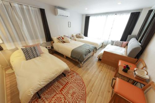 a room with two beds and a couch at SAKURA INN Asakusa station walking 4 Min Shinjuku Shibuya Ginza Oshiage in Tokyo