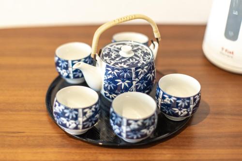 a group of blue and white cups and a teapot at SAKURA INN Asakusa station walking 4 Min Shinjuku Shibuya Ginza Oshiage in Tokyo