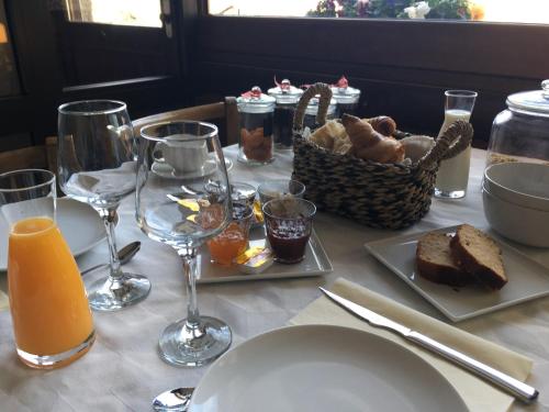 a table with a plate of bread and glasses of orange juice at Auberge à la Vieille Cure in Arandas