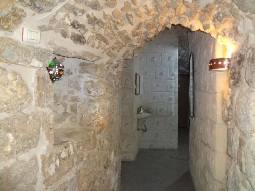 uma casa de banho com paredes de pedra, um lavatório e um WC. em Jaffa Gate Hostel em Jerusalém