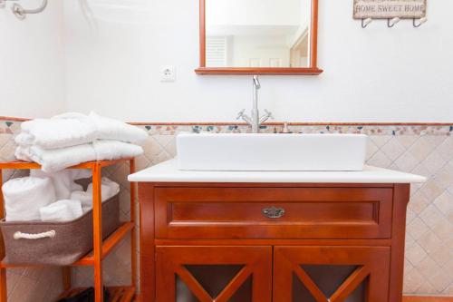 ein Bad mit einem Waschbecken und einem Spiegel in der Unterkunft Villa Grandpa Luka in Baška Voda