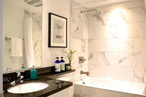 a bathroom with a sink and a bath tub and a sink at HEART OF WEST HOLLYWOOD MODERN SUITE 2 BEDROOM 2 BATH in Los Angeles