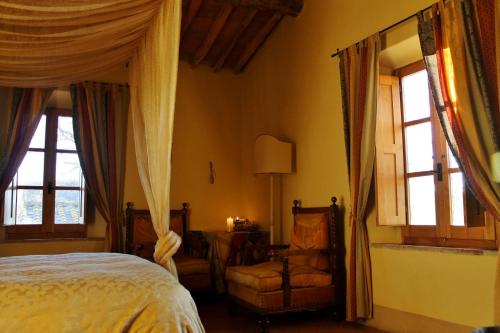 a bedroom with a bed and a chair and windows at Centro Ippico Della Berardenga in Castelnuovo Berardenga