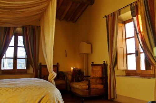 Un dormitorio con una cama y una silla y ventanas. en Centro Ippico Della Berardenga, en Castelnuovo Berardenga