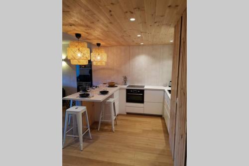 une cuisine avec des armoires blanches et une table à l'intérieur dans l'établissement Charmant Mazet Haut de Gigaro, face à la pinède, à La Croix-Valmer