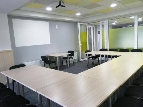 a conference room with tables and chairs and a whiteboard at Hotel & Spa Tino Sveti Stefan in Ohrid