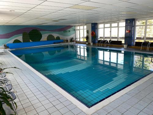 ein großer Pool mit blauen Fliesen in einem Gebäude in der Unterkunft Hotel Lugsteinhof in Kurort Altenberg