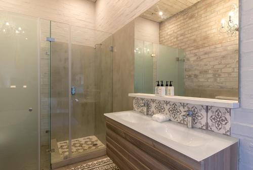 a bathroom with a sink and a glass shower at The Quarter Deck in Kenton on Sea