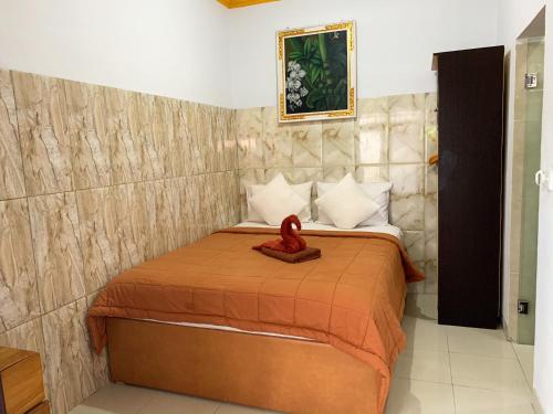Un dormitorio con una cama con un corazón rojo. en Gustav Bali Homestay and Massage, en Sanur