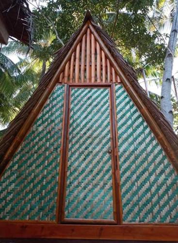 a building with a roof with a glass door at SHUKRAN Apartelle in Siquijor