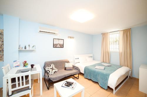 a hotel room with a bed and a couch at Cozy Studio "De Shalit" in Herzliya