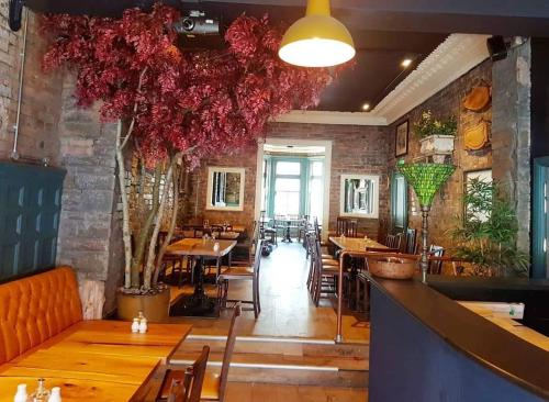 a restaurant with tables and chairs and a brick wall at Glendale Hotel in Cardiff