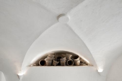a light in a ceiling with a bunch of pipes at Winery Hotel 1870 in Fira