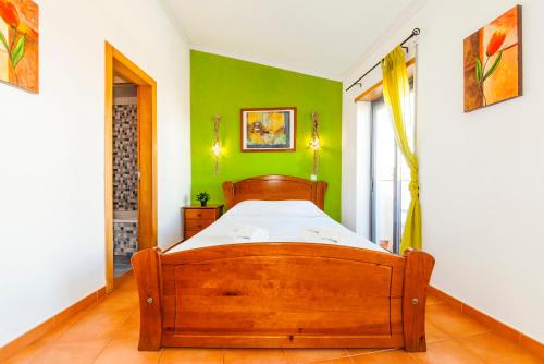 a bedroom with a wooden bed with a green wall at A09 - Super Central Duplex Apartment in Lagos