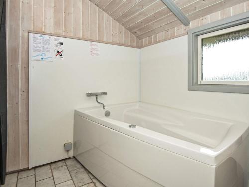 una vasca bianca in un bagno con finestra di Three-Bedroom Holiday home in Sjølund 1 a Hejls