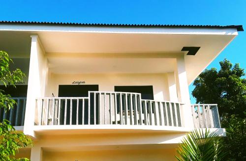 a white house with a balcony on it at Adayo Cove Resort in Siquijor