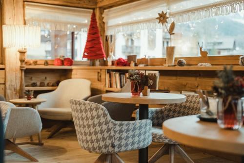 a restaurant with tables and chairs in a room at FIORI Dolomites Experience Hotel in San Vito di Cadore