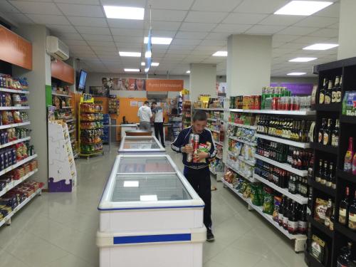 a woman is standing in a store aisle at HOTEL Apartments ARDO in Golem