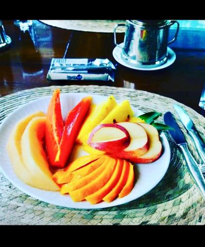 a plate of fruits and vegetables on a table at Mar Verde Lodge in Puerto Viejo